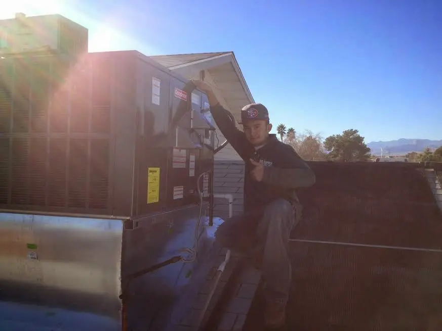 HVAC technician performing AC Tune-Up on a rooftop unit in Cinnaminson